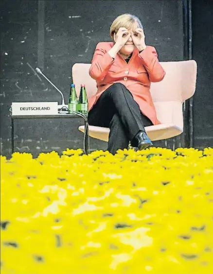  ?? ILMARS ZNOTINS / AFP ?? Angela Merkel bromea frente a la alfombra de flores situada en el centro de la reunión