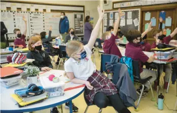  ?? ERIN HOOLEY/CHICAGO TRIBUNE PHOTOS ?? Casey Gallagher, 10, raises her hand Wednesday in math class at St. Benedict Catholic School in Chicago.