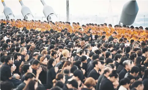  ?? — AFP photo ?? 999 Buddhist monks lead prayers in honour of the late Thai King Bhumibol Adulyadej to commemorat­e his birthday on top of Bhumibol Bridge in Bangkok.