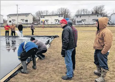  ?? SUBMITTED BY STEPHEN MACDOUGALL ?? A new outdoor rink at Robin Foote Elementary in Westmount is just about ready to go. School and community members are shown putting it together.