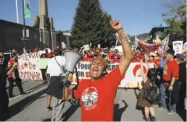  ?? Michael Macor / The Chronicle 2015 ?? Samuel Barron leads a chant as fast-food workers march for a higher minimum wage in Berkeley in 2015. Federal rules could impact the state’s.