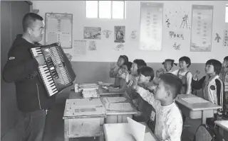  ?? CHEN BIN / XINHUA  PROVIDED TO CHINA DAILY ?? Right: Music teacher Wang Fengfeng gives a lesson at a village school in Shangyuan, Longcheng.
Far right: Song Juanli teaches pupils at Shanwang Primary School to sing.