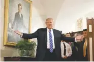  ?? THE ASSOCIATED PRESS ?? President Donald Trump greets visitors touring the White House in Washington on Tuesday. A portrait of former first lady Hillary Clinton, Trump’s election opponent, hangs over his shoulder.