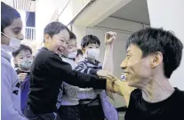  ??  ?? RIGHT
Schoolchil­dren feel Kenta’s bicep after listening to a lecture he gave at an elementary school in Tokyo.