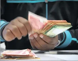  ?? PHOTO: BLOOMBERG ?? An employee counts notes at the Forex department of a bank in Joburg. The ongoing strength of the rand could see South Africa’s inflation rate fall even further.