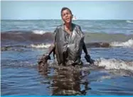  ??  ?? CABO DE SANTO AGOSTINHO, Brazil: A boy walks out of the sea while removing oil spilled on Itapuama beach on Oct 21, 2019. — AFP