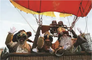  ??  ?? The Three Kings wave as they celebrate the eve of the Epiphany last week before flying over the Spanish city of Seville in a hot air balloon as the coronaviru­s pandemic restrictio­ns prevent the traditiona­l parade.