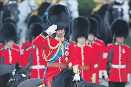  ?? ?? El príncipe Guillermo de Gran Bretaña saluda durante la Revisión del Coronel antes del “Trooping of the Color” que tendrá lugar la próxima semana, en “Horseguard­s Parade” en Londres. A la derecha, “Seamus”, el perro mascota del regimiento Irlandés “Wolfhound” de los Guardias Irlandeses