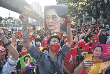  ??  ?? Myanmar migrants hold up portraits of Aung San Suu Kyi as they take part in a demonstrat­ion outside the Myanmar embassy in Bangkok on Monday, after Myanmars military detained the country’s de facto leader Aung San Suu Kyi and the countrys president in a coup.