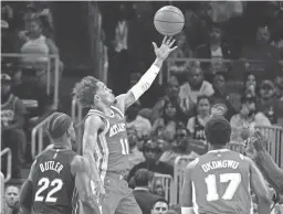  ?? DALE ZANINE/USA TODAY SPORTS ?? Hawks guard Trae Young scores a basket behind Heat forward Jimmy Butler during the first half on Friday in Atlanta.