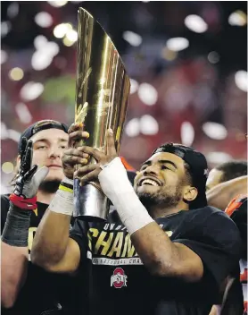  ??  ?? Ohio State quarterbac­k Cardale Jones hoists the championsh­ip trophy after the Buckeyes beat the Oregon Ducks on Monday in Arlington, Texas.