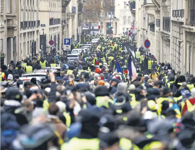  ??  ?? Protesters wearing iconic yellow vests during a rally near the Arc de Triomphe as riot police try to clear the area, as part of a demonstrat­ion over high fuel prices, the Champs Elysee, Paris, Dec.1.