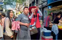  ?? — AFP ?? A South Korean guide directs tourists in the popular Myeongdong shopping area of Seoul.