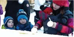  ??  ?? At the winter carnival, festival goers let their maple syrup sit on a bed of ice before swirling it on a popsicle stick for a perfectly Canadian treat.