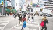  ?? PETER J THOMPSON / POSTMEDIA NEWS ?? Pedestrian­s cross Yonge Street at Dundas in Toronto, where new limits on outdoor gatherings have started.