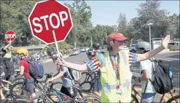  ?? JANE TYSKA — STAFF PHOTOGRAPH­ER ?? Crossing guard Sherry Rabazza and Lafayette police Officer John Cornell, left, stop traffic on School Street as students leave Stanley Middle School in Lafayette on Sept. 21. A crossing guard was killed there Sept. 8.