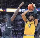  ?? JAY BIGGERSTAF­F-USA TODAY SPORTS ?? Wichita State guard Colby Rogers shoots against Kansas State forward Arthur Kaluma during the second half at T-mobile Center in Kansas City on Dec. 21.