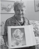  ?? Associated Press ?? In this Jan. 19, 2011, file photo, retired hairstylis­t Margaret Vinci Heldt, poses for a photo at her apartment in Elmhurst, Ill., with a picture of a model with a “beehive” hairdo from the February 1960 edition of Modern Beauty Shop magazine. Heldt,...