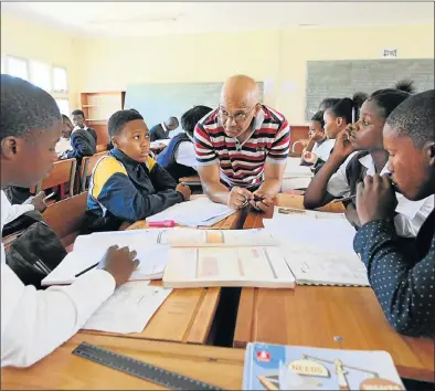  ?? Picture: FREDLIN ADRIAAN ?? MATHS MOTIVATION: Mark Baartman, centre, helps Thubelihle High School pupils, from left, Kamvelihle Dastile, 19, Lukhona Bala, 16, Elethu Dikana, 19, and Sesethu Qaniyana, 19, with their mathematic­s