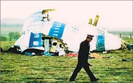  ?? Martin Cleaver Associated Press ?? A POLICE OFFICER walks by the nose of Pan Am Flight 103 in a field near the town of Lockerbie, Scotland, on Dec. 21, 1988. The bombing killed 270 people.