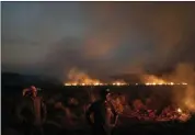  ?? LEO CORREA — THE ASSOCIATED PRESS ?? Neri dos Santos Silva, center, watches an encroachin­g fire threat after digging trenches to keep the flames from spreading to the farm he works on, in the Nova Santa Helena municipali­ty,