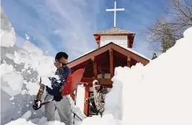  ?? Mario Tama/getty Images ?? Residents shovel snow after a series of winter storms in the San Bernardino Mountains. California is expecting another atmospheri­c river storm.