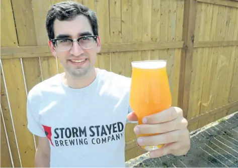  ?? MORRIS LAMONT/THE LONDON FREE PRESS ?? Storm Stayed Brewing Company co-owner Justin Belanger hoists a glass of the new brewery’s lager.