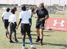  ??  ?? SKILLS developmen­t coach Riaan O’Neill with aspiring soccer stars during the pro coaching skills initiative at the weekend.