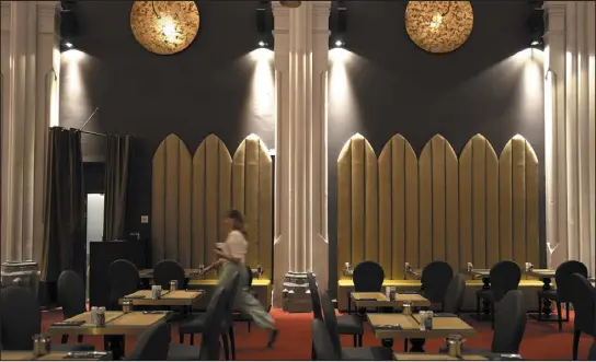  ?? PHOTOS BY VIRGINIA MAYO — THE ASSOCIATED PRESS ?? A woman walks through the dining room of the Martin’s Patershof hotel in Mechelen, Belgium, on June 19. Across Europe, many churches, convents and chapels are being repurposed to preserve their historical and architectu­ral relevance.