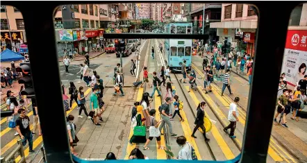  ?? — AFP ?? People crossing a road are seen through the window of a tram in Hong Kong on Saturday. A proposal to enact new Hong Kong security legislatio­n was submitted, state media said, a move expected to fan fresh protests in the semi-autonomous financial hub.