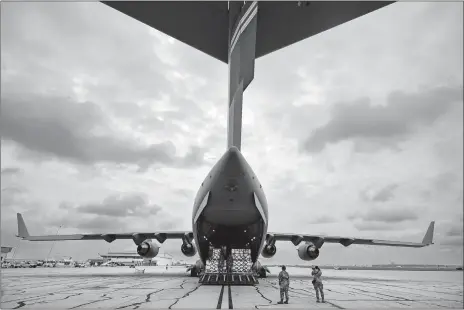  ?? MICHAEL CONROY/AP PHOTO ?? The crew of an Air Force C-17 begins to unload a planeload of baby formula at the Indianapol­is Internatio­nal Airport. The 132 pallets of formula arrived Sunday from Germany.