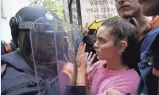  ?? PAU BARRENA, AFP/GETTY IMAGES ?? Police push back crowds outside a polling station in Barcelona.