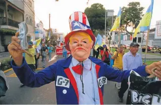  ?? AP/ KAREL NAVARRO ?? A man wearing a mask that depicts US President Donald Trump participat­es in a protest against the Summit of the Americas, in Lima, Peru.