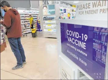  ?? David Zalubowski The Associated Press ?? A patient waits to be called for a COVID-19 vaccinatio­n booster shot on Wednesday at a pharmacy inside a grocery store in downtown Denver.