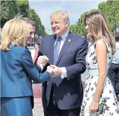  ??  ?? BETTER DAYS: French President Emmanuel Macron, second left, shakes hands with US President Donald Trump after the Bastille Day military parade in 2017.