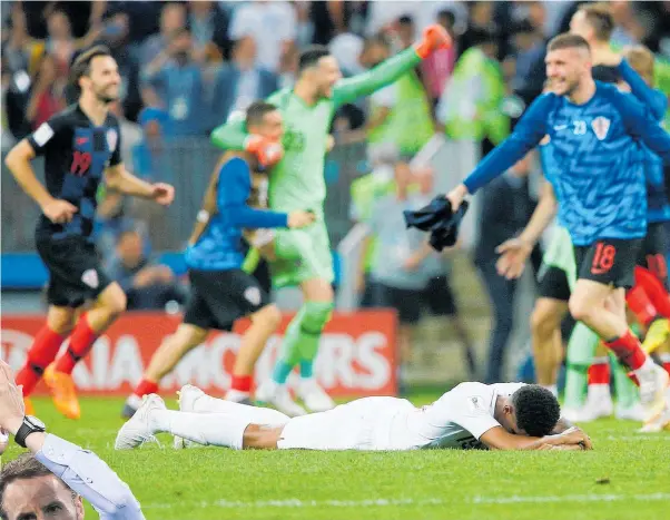  ??  ?? Croatian players celebrate as gutted England forward Marcus Rashford lays prone on the pitch. Inset: Gareth Southgate.