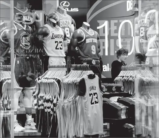  ?? JEENAH MOON/GETTY-AFP ?? Apparel is displayed at the NBA Store in New York City on Thursday — the day after the league suspended its season following Rudy Gobert’s positive test for the Coronaviru­s.