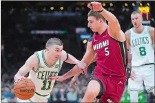  ?? STEVEN SENNE/AP PHOTO ?? Boston Celtics guard Payton Pritchard (11) drives toward the basket as Miami Heat forward Nikola Jovic (5) defends in the first half of Game 1 of an NBA first-round playoff series on Sunday in Boston.