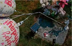 ?? ?? Tatiana visited the grave site of her 1-month-old baby who died while sleeping in the same bed with her in 2015. “Happy Birthday” balloons floated over the headstone of her daughter’s burial site. The mother visits every year on the infant’s birthday.
