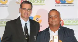  ??  ?? Angelo Bush of Melkhoutfo­ntein Cricket Club (right) receives the trophy as groundsman of the season from Jean Neethling, chairman of the SWD Cricket Umpires Associatio­n.