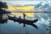  ?? PTI ?? A man rows a boat at a village in Thiruvanan­thapuram on Sunday.