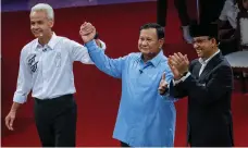  ?? EPA; AFP ?? Top, electoral officials prepare ballot papers in Tangerang, near Jakarta, Indonesia; above, presidenti­al candidates, from left, Ganjar Pranowo, Prabowo Subianto and Anies Baswedan