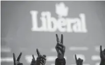  ?? REUTERS/STEPHANE MAHE ?? Liberal Party supporters flash V-signs while watching the live federal election results at the Palais des Congres in Montreal, Monday.