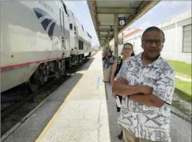  ?? AP PHOTO/MIKE SCHNEIDER ?? Jishnu Mukdrji and Penny Jacobs wait to board an Amtrak train in Orlando, Fla. Murkdrji and Jacobs became friends from online train forums that get other rail enthusiast­s together for trips around the United States. They were headed to Pennsylvan­ia for a memorial service for one of the members in their train group who died of a heart attack in July while traveling with his train buddies to New Orleans.