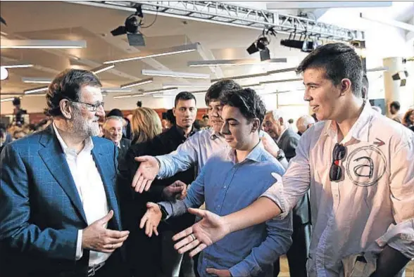  ?? JAVIER BELVER / EFE ?? El presidente del PP, Mariano Rajoy, saluda a jóvenes militantes del partido ayer en Zaragoza, donde clausuró la convención sobre educación