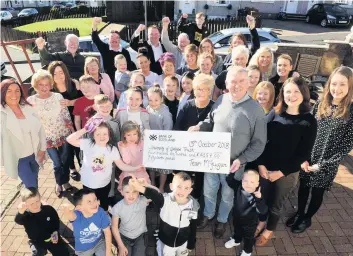  ??  ?? Team effort The McGuigans, led by Maureen and John (centre), celebrate their latest donation