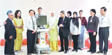  ??  ?? Jamilah hands over a cardiac equipment to head of Sarawak Heart Centre’s Cardiology Department Dr Ong Tiong Kiam while Dr Asri (on her left) and others look on.