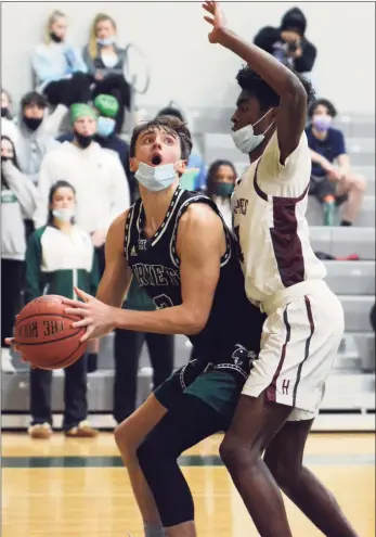  ?? Dave Phillips / For Hearst Connecticu­t Media ?? Alex Puhl of Hamden Hall looks for an open shot while being defended by Ezra Fearon of Hopkins on Monday.