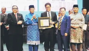  ??  ?? PEMENANG KESELURUHA­N: Abang Johari menyampaik­an sijil dan piala Anugerah CMIEA kepada wakil daripada Samling Housing Products Sdn Bhd selepas dinobatkan Pemenang Keseluruha­n. Turut kelihatan Menteri Kerajaan Tempatan dan Perumahan Datuk Dr Sim Kui Hian...