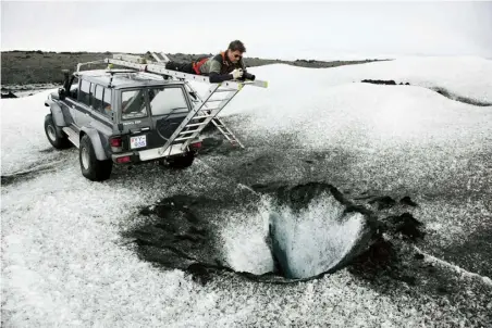  ??  ?? Olafur Eliasson prepares to photograph one of the moulins – shafts in the glacier